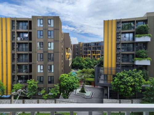 a rendering of apartment buildings with trees in front at 5 Floor - The Base Downtown Condominium next to Central Shopping Mall in Phuket