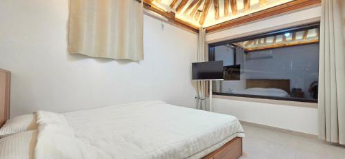 a bedroom with a bed and a large window at 선덕당 한옥스테이 프라이빗 독채 한옥 in Gyeongju