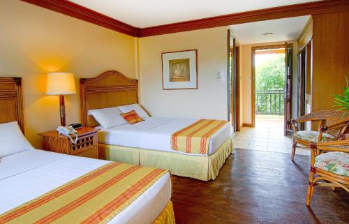 um quarto de hotel com duas camas e uma varanda em Boracay Tropics Resort Hotel em Boracay