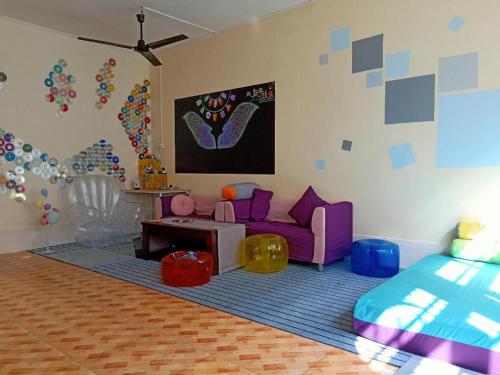 a living room with a purple couch and a bed at Beihai forget dust International Youth Hostel in Beihai