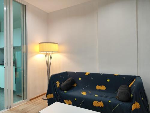 a living room with a blue couch with pumpkins on it at 5 Floor - The Base Downtown Condominium next to Central Shopping Mall in Phuket