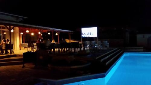 a swimming pool at night with a stage in the background at Paradise in Kérynia