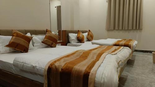 two beds sitting next to each other in a room at Shri ShyamRaj Hotel Ujjain in Ujjain