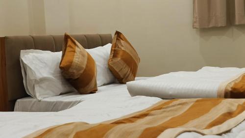 two beds with pillows sitting next to each other at Shri ShyamRaj Hotel Ujjain in Ujjain