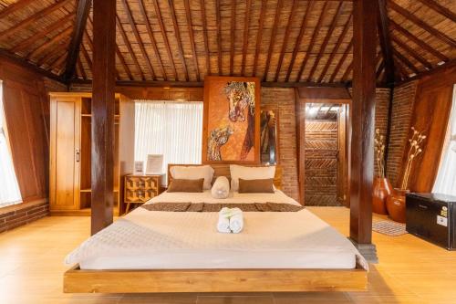 a bedroom with a bed with two towels on it at Villa Kaluna - 3 Bedroom Javanese Villa in Kaliurang in Bedoyo