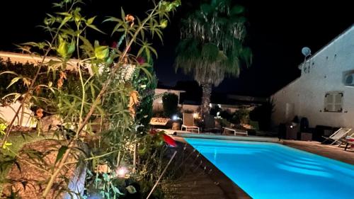 a swimming pool in front of a house at night at Mini Villa Pascal Paoli avec piscine - proche mer in Prunelli-di-Fiumorbo