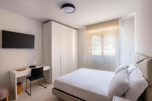 a bedroom with a bed and a desk and a television at DOMUS Matteotti in Ancona