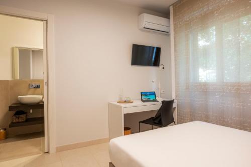 a bedroom with a bed and a desk with a laptop at DOMUS Matteotti in Ancona