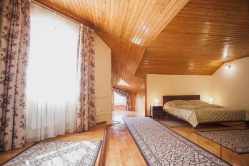 - une chambre avec un lit et une grande fenêtre dans l'établissement Saxony Dim, à Tchernivtsi