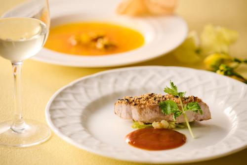 a white plate with a piece of meat and a glass of wine at Laforet Hakone Gora Yunosumika in Hakone