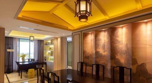 a dining room with a dining table and a ceiling at Yuan Culture Hotel Shenzhen World Shajing in Shenzhen