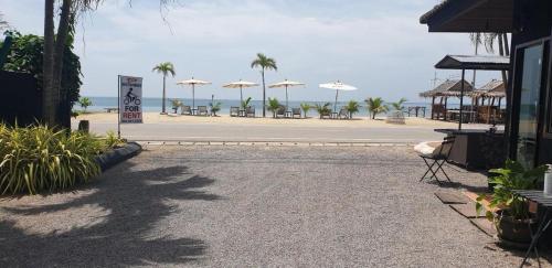 a parking lot with tables and umbrellas on the beach at Seascape Resort Baan Krood in Ban Krut