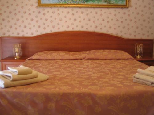 a bedroom with a bed with towels on it at Hotel Bed & Breakfast Minu' in Paravati