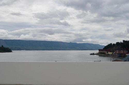 a view of a large body of water with mountains at OPRISS HOTEL in Parapat