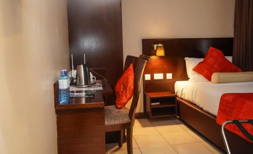 a hotel room with a bed and a desk with a computer at Hotel Rio in Nairobi