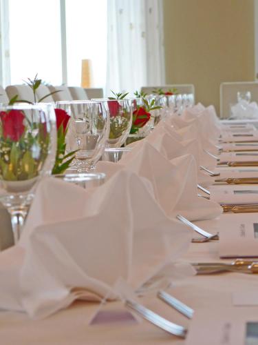 a table with white napkins and wine glasses on it at Åkerby Herrgård in Nora