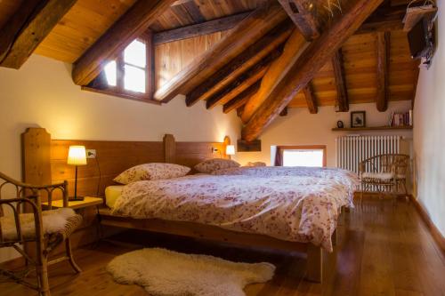 a bedroom with a bed and a window and wooden ceilings at Tre Alberi Liberi in Alagna Valsesia