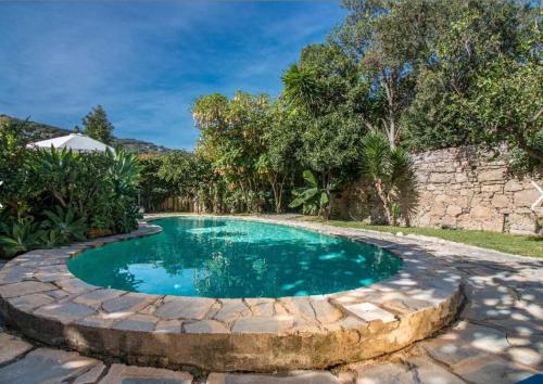 a swimming pool with a stone path around it at Casa rural en el Parque Natural de los Alcornocales in Jimena de la Frontera