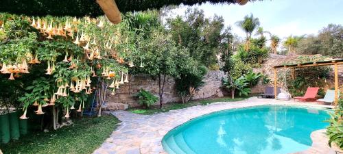 a swimming pool in a yard with a stone wall at Casa rural en el Parque Natural de los Alcornocales in Jimena de la Frontera
