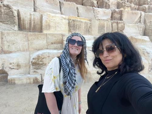 two women standing in front of a stone wall at Cairo Pyramids View Hostel & Apartment in Cairo