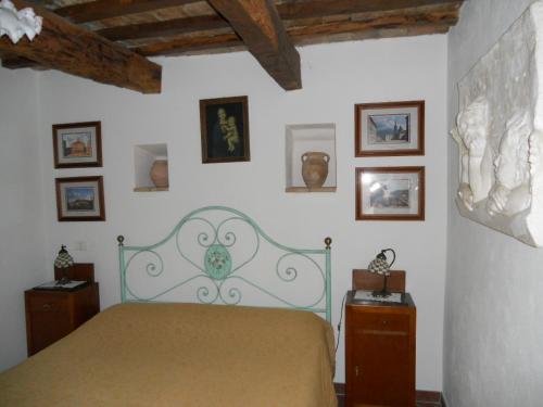 a bedroom with a bed and some pictures on the wall at Il Castello in Monte Cerignone