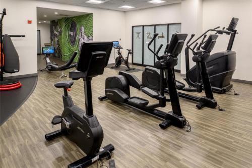 a gym with several treadmills and cardio machines at Hilton St. Louis Airport in Woodson Terrace