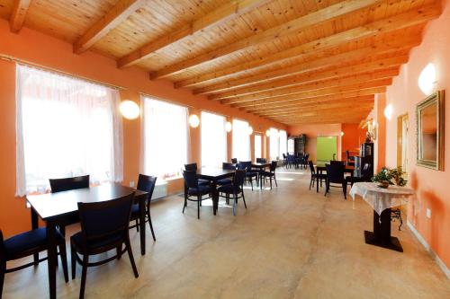 a dining room with tables and chairs and windows at Penzion Folbr in Dlouhá Lhota