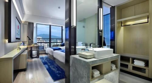 a bathroom with a sink and a bathroom with a bed at Echarm Hotel Guilin North High Speed Railway Station in Guilin