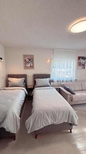 un dormitorio con dos camas y un sofá en Nisay Home, Apart Suite, N2, en Ludwigsburg