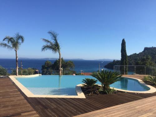 une piscine avec vue sur l'océan dans l'établissement Les Lauriers Roses, à Rayol-Canadel-sur-Mer
