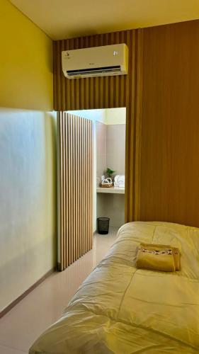 a bedroom with a bed with a bag on it at BEE ROOM Sanur in Sanur
