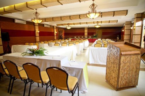 a banquet hall with white tables and chairs at Boracay Tropics Resort Hotel in Boracay