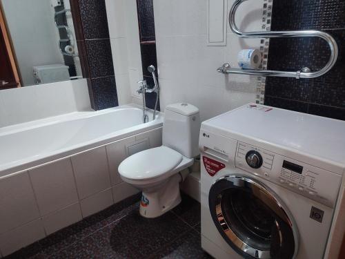 Un baño con inodoro y lavadora. en Apartment on Tole Bi, en Almaty
