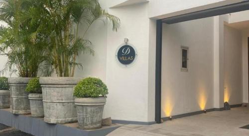 a sign on the side of a building with potted plants at D Villas in Colombo