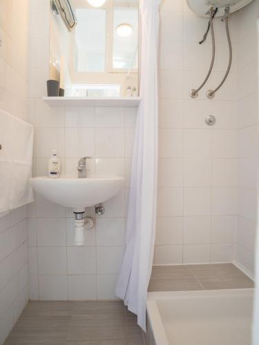 a white bathroom with a sink and a shower at Apartment Ana in Pula