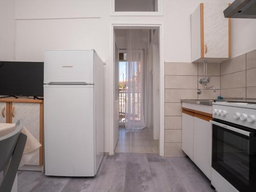 a white kitchen with a refrigerator and a sink at Apartment Ana in Pula