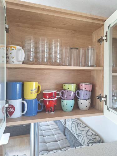 a cupboard filled with lots of cups and bowls at Sunset Spot à Bredene in Bredene