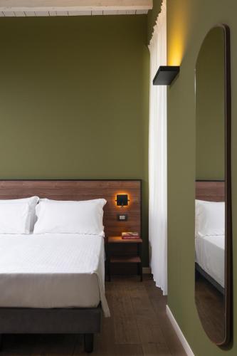 a bedroom with a large bed and a mirror at Locanda Cece e Simo in Bergamo