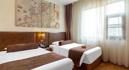 a hotel room with two beds and a map on the wall at James Joyce Coffetel Xi'an Lingtong The Terracotta Army Huaqingchi University Town Metro Station in Xi'an