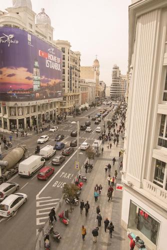a busy city street with cars and people on the street at Petit Palace Triball in Madrid