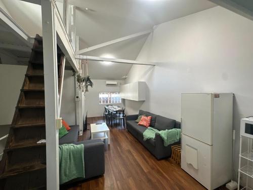 a living room with a couch and a staircase at 3BR Entire Home, 1 Min to Midosuji Line, Sleeps 10 in Osaka