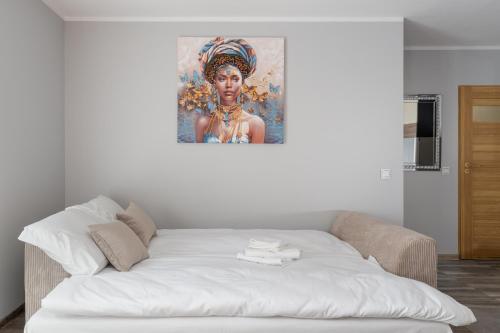 a white couch in a room with a painting on the wall at Osiedle Piastów Charming Apartment by BookingHost in Kraków