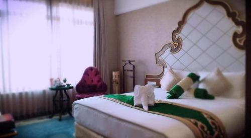 a hotel room with a bed with a stuffed animal on it at Hohhot Inner Mongolia Hotel in Hohhot
