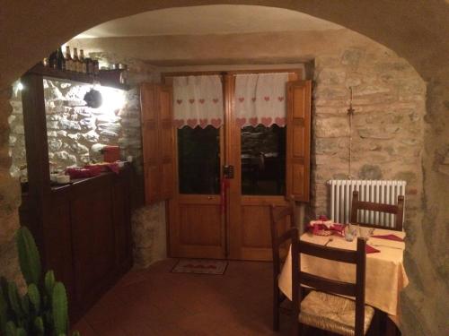 a dining room with a table and a door at Agriturismo I Chiosi in Comano