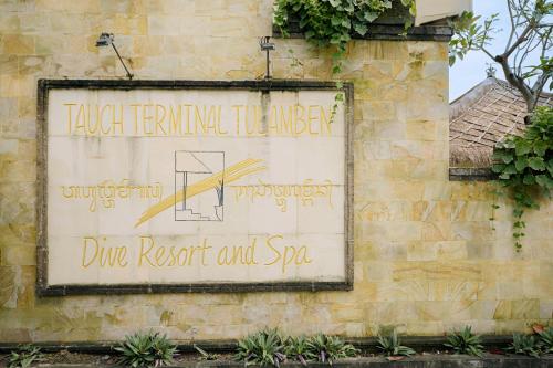 a sign on the side of a building at Tauch Terminal Resort Tulamben & Spa in Tulamben