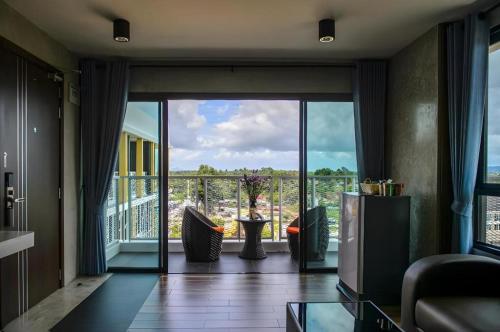 a living room with a large glass door to a balcony at B2 Krabi Premier Hotel in Ao Nang Beach