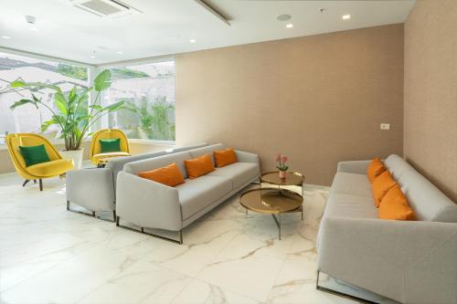 a living room with two couches and orange pillows at Melia Venezia Lido in Venice-Lido