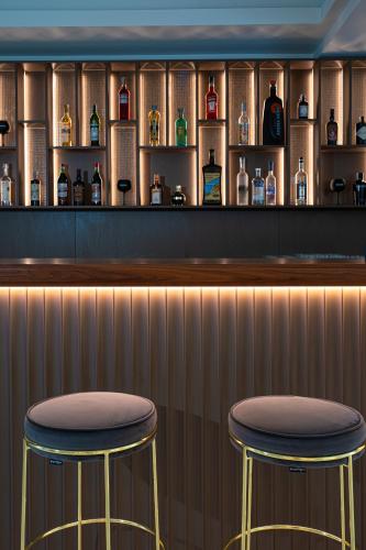 two stools at a bar with bottles of alcohol at Melia Venezia Lido in Venice-Lido