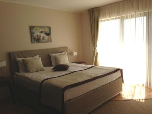 トポラにあるApartment in Thracian Cliffs Resortのベッドルーム1室(大きなベッド1台、大きな窓付)