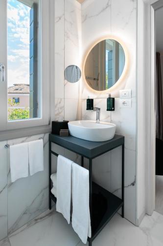 a bathroom with a sink and a mirror at Melia Venezia Lido in Venice-Lido
